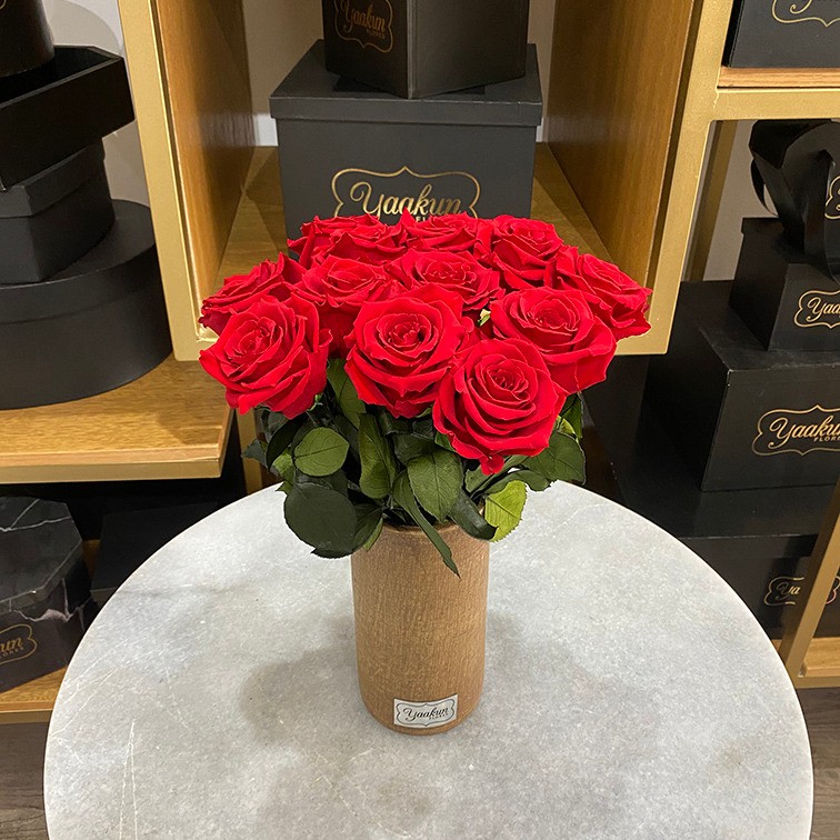 12 rosas eternas rojas en jarrón tono madera