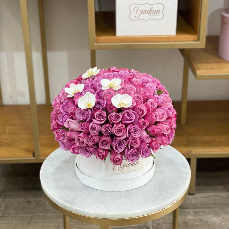 150 rosas lilas en caja circular blanca con 5 orquídeas blancas