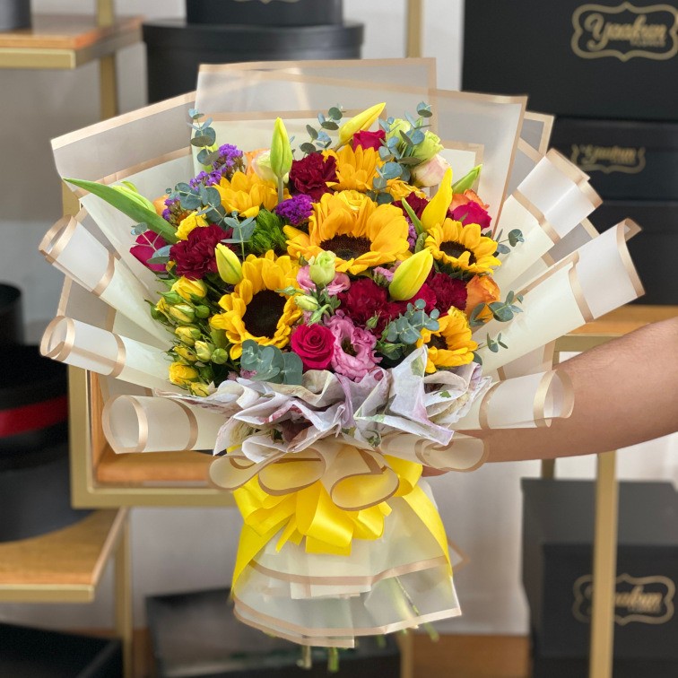 Bouquet colorido con girasol, tulipanes,baby rose, rosa y lisianthus con papel coreano