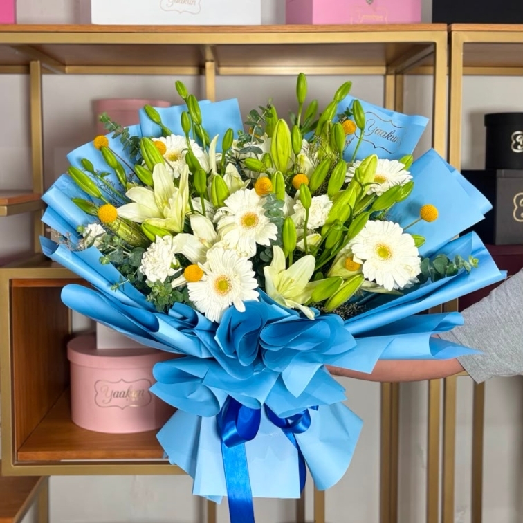 Bouquet de lilis, gerbera y craspedia con papel azul