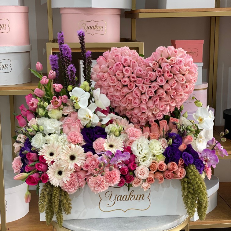 Caja blanca con corazon de 100 rosas rositas y jardin en tonos rosas y lilas