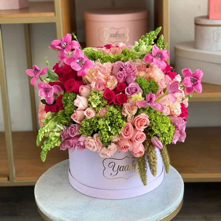 Caja circular lila con 75 rosas rosas, lilas y toques verdes