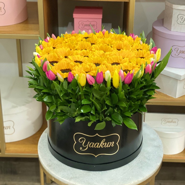 Caja circular negra con 50 tulipanes y 15 girasoles aprox