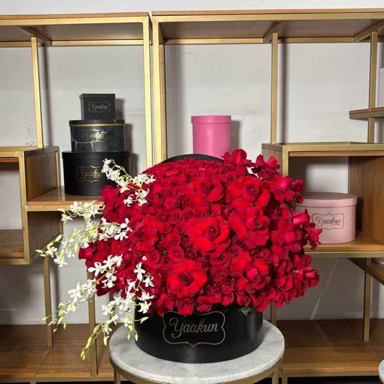 Caja circular negra media esfera con 350 rosas rojas y dendrovium