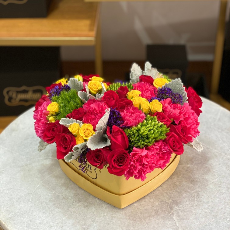 Caja corazón dorado con tapa con 25 rosas, toques baby rose, clavel, lisianthus y follajes finos