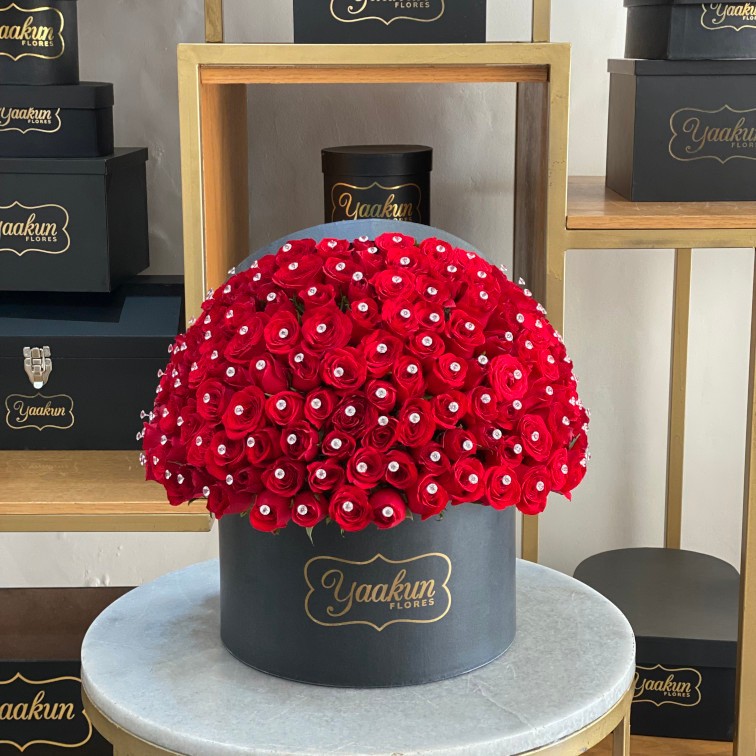 Caja negra circular con 150 rosas rojas y pines