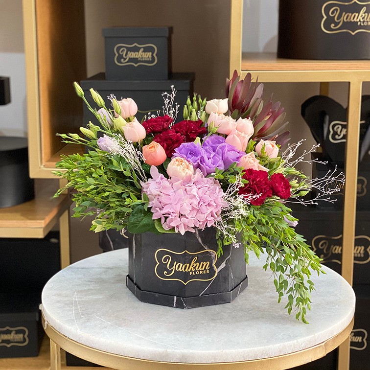 Caja octagonal negra con 10 rosas inglesas y follajes finos
