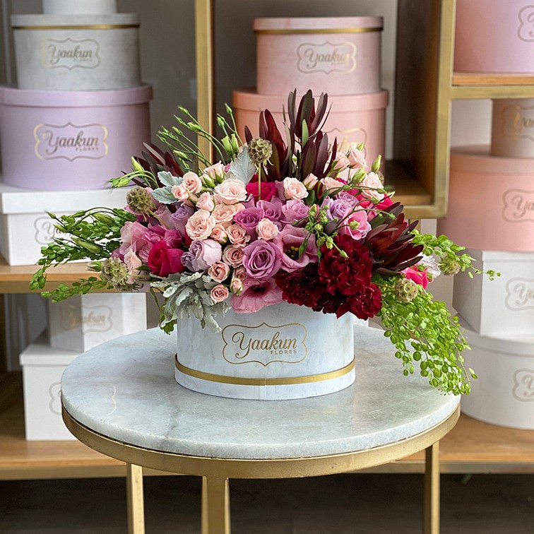 Caja ovalada blanca con 75 rosas en tonos rosas & tintos