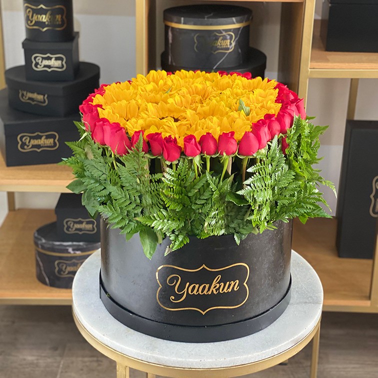 Caja redonda negra con girasoles y rosas amanecer soleado