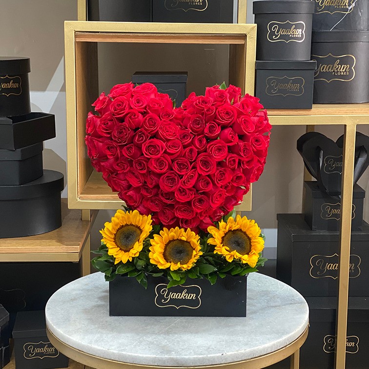 Corazón en escultura de 100 rosas rojas & 3 girasoles en la base caja negra