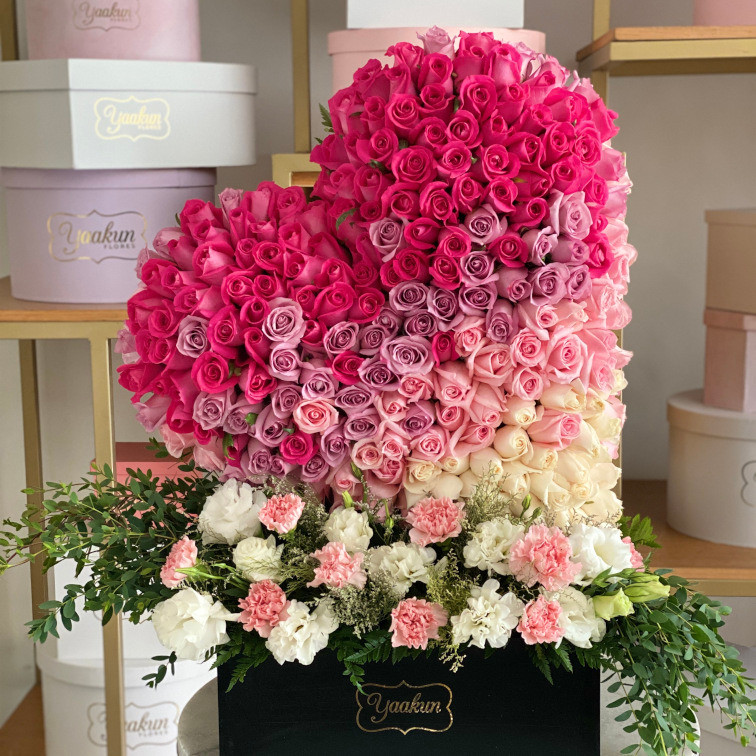 Escultura de 250 rosas en forma de corazón degrade inclinado en caja negras con jardín