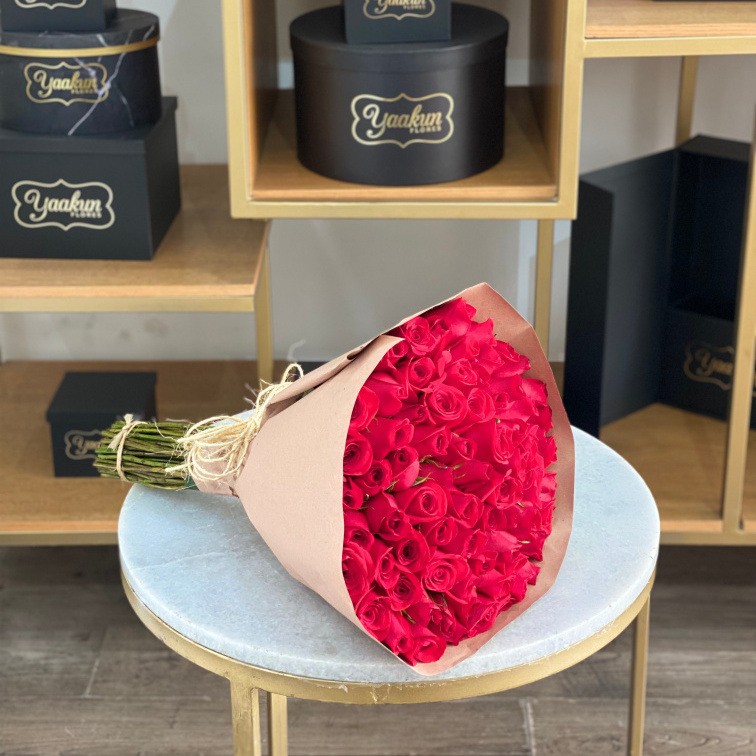 Maxi ramo de 100 rosas rojas con papel destraza y moño de mecate