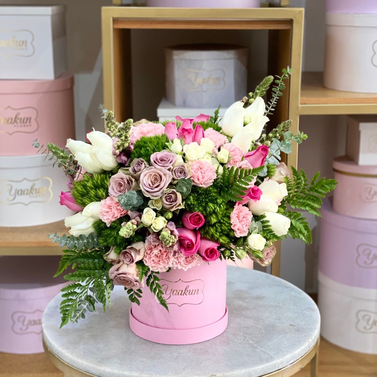 Mini caja circular rosita con 50 rosas mixtas, perritos, leder, clavel y dólar