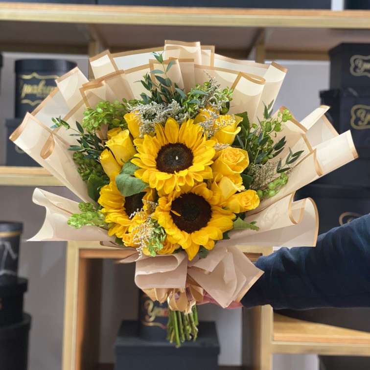 Ramo de 12 rosas amarillas con 3 girasoles y follajes, con papel coreano