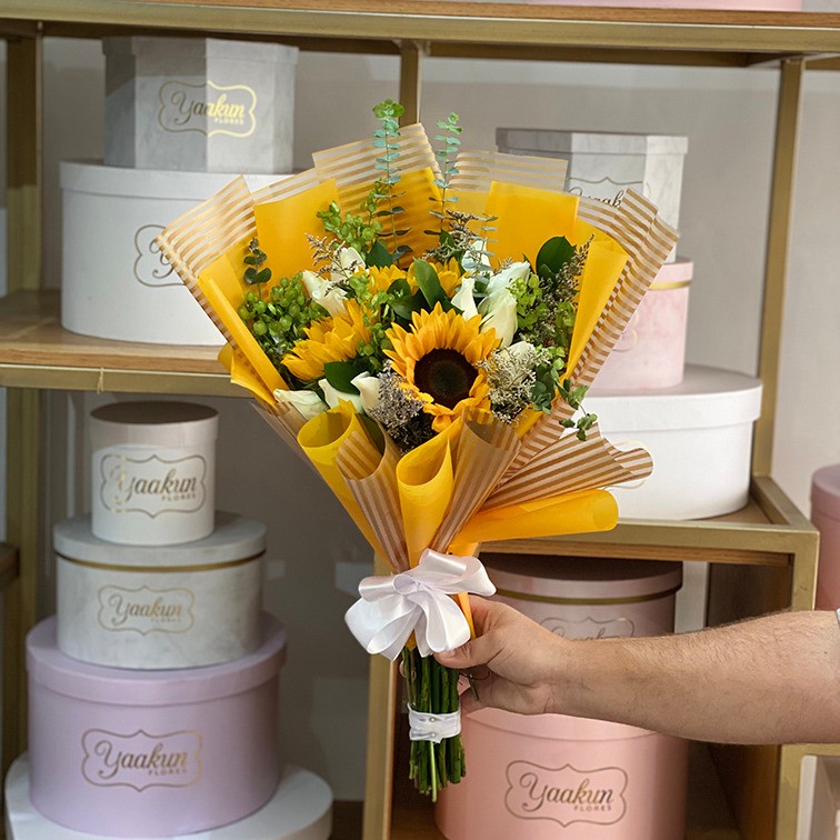 Ramo de 12 rosas blancas y 3 girasoles con follajes y papel celofan