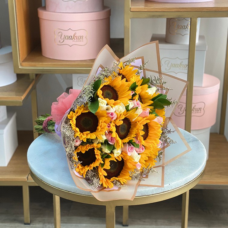 Ramo de 25 rosas tonos pastel y 10 girasoles y follaje
