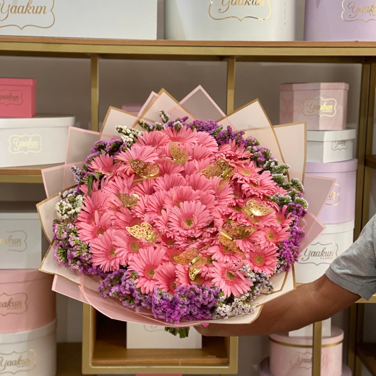 Ramo de 60 gerberas rositas con leticia y 8 mariposas con papel coreano
