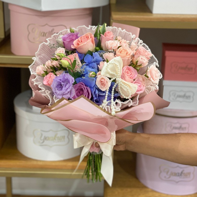 Ramo en tonos rositas y lilas con 10 rosas, maya y papel coreano