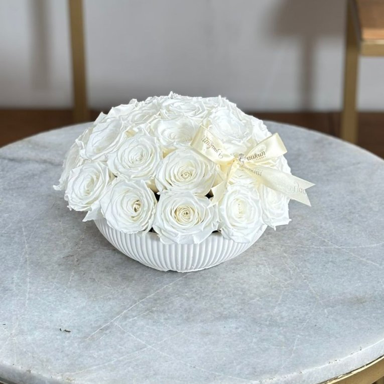 Rosas eternas blancas en tazón blanco