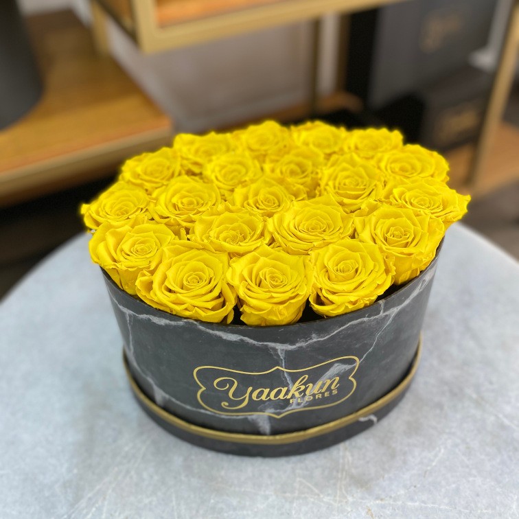 Rosas eternas en caja ovalada negra con rosa amarilla