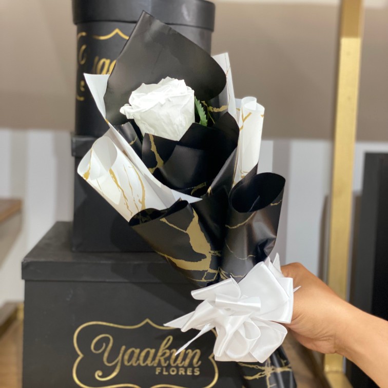 Tallo de rosa eterna blanca con papel celofán