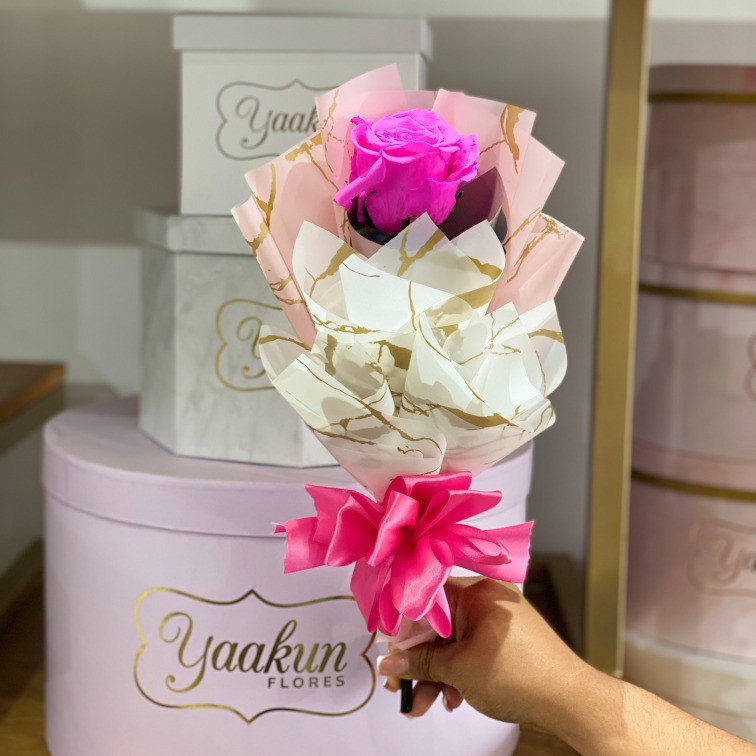 Tallo de rosa eterna fucsia con papel celofán