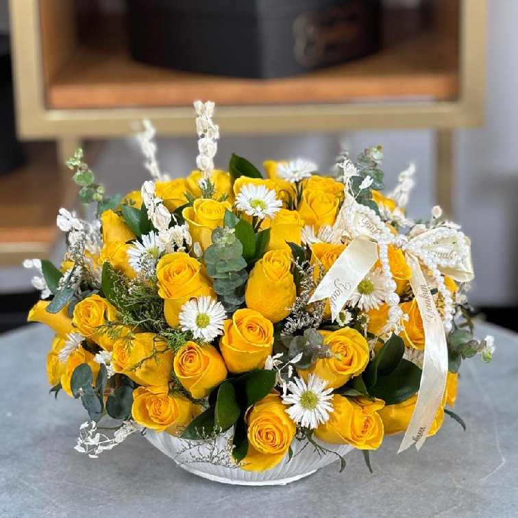 Tazón blanco con 50 rosas amarillas y follajes